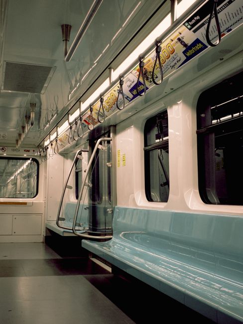 Close-up view of two upholstered train seats on Oakleigh Park station, with dark blue patterned fabric featuring red and gray streaks, showing minimal signs of wear and dirt. The seats are positioned
